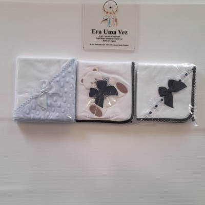 Três panos de bebé embrulhados em plástico, com detalhes em azul, branco e preto.