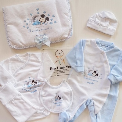 Conjunto de roupa de bebé azul e branca com boneco Mickey adormecido e texto A minha primeira roupinha
