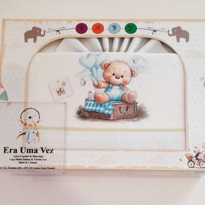 Toalha de bebé branca com bordado de urso, em caixa decorada com elefantes.