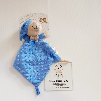Manta de peluche azul com cabeçote bege e embalagem branca
