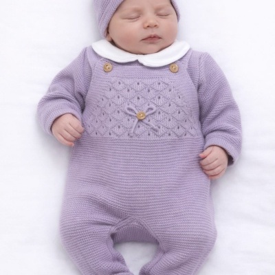 Bebé a dormir com macacão e gorro lilás de malha e gola branca sobre fundo branco