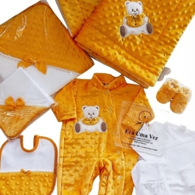 Conjunto de roupa de bebé amarelo com estampas de ursinho e textura de bolinhas, e roupa branca simples