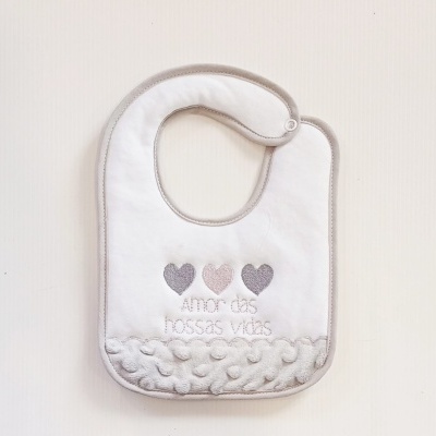 Babete branco com bordas cinza e decoração com corações e texto bordado