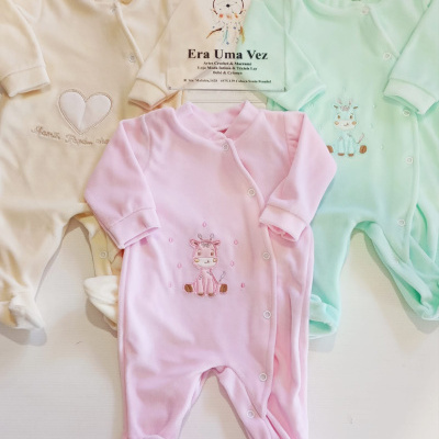 Três macacões de bebé em tecido macio com botões frontais nas cores bege, rosa e verde, com desenhos bordados, e placa com texto da loja Era Uma Vez.
