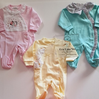 Três macacões de bebé coloridos com detalhes bordados e babados
