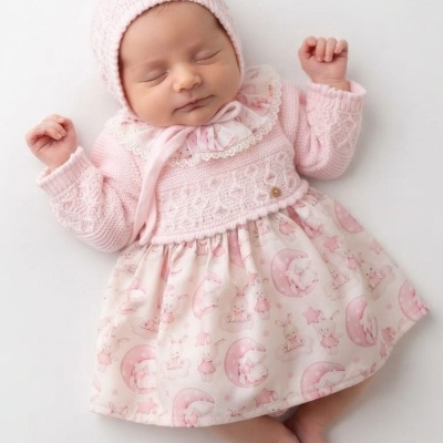 Bebé vestido com vestido e cardigan rosa, deitado
