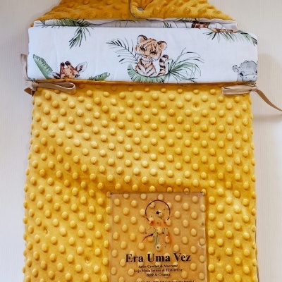 Saco de bebé amarelo com textura e padrão de animais na parte interior.