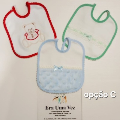 Três babetes para bebé em branco com bordas vermelha, verde e azul, com diferentes decorações, sobre fundo branco com texto Era Uma Vez e opção C.