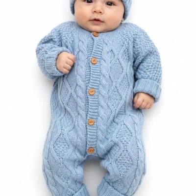 Bebé com fato de malha azul claro e gorro com pompom