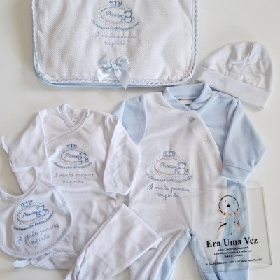 Conjunto de roupa de bebé branco e azul com padrão bordado e saco com texto Era Uma Vez