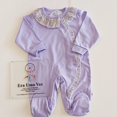 Macacão de bebé lilás com folhos florais e botões metálicos sobre fundo branco