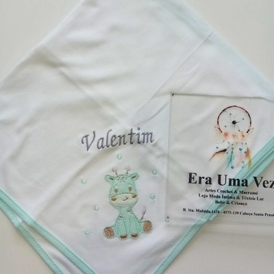 Fralda branca bordada com desenho de girafa e nome 'Valentim'