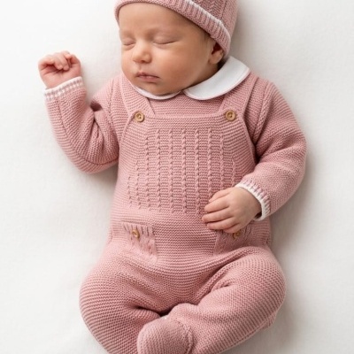 Bebé a dormir com fato e gorro de malha rosa