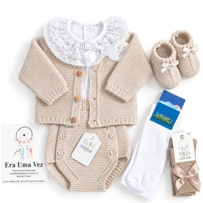 Conjunto de roupas de bebé bege e branco com casaco, body com gola rendada, cueiro, meias e botins.