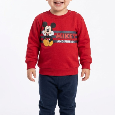 Menino com camisola vermelha Mickey e calças azuis escuras em fundo branco