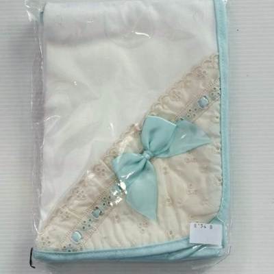 Manta branca para bebé com borda azul clara e laço azul, embalada em plástico transparente