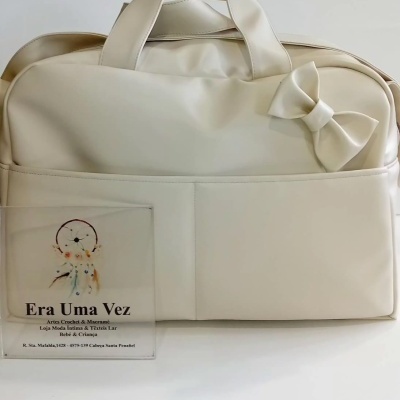 Mala creme com laço decorativo e placa transparenta com texto