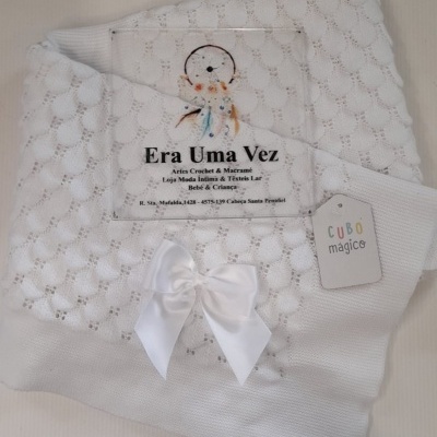 Manta branca para bebé com laço branco e etiqueta CUBO mágico