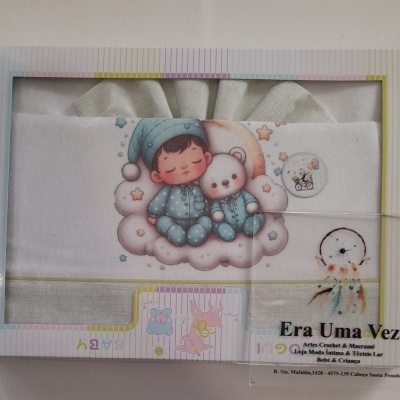 Produto têxtil para bebé com ilustração de criança e ursinho de pijama azul numa nuvem.