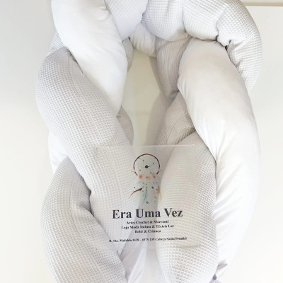 Almofada entrelaçada branca com textura quadriculada e etiqueta, sobre fundo branco