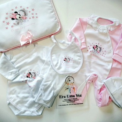 Conjunto roupa de bebé branco e rosa com desenho da Minnie Mouse e texto em português.