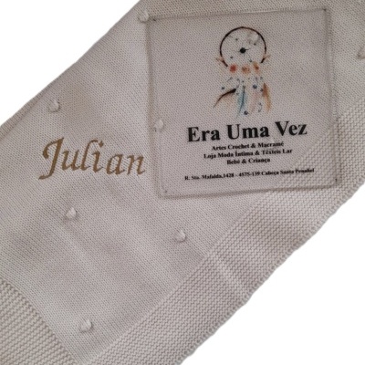 Manta bege de malha com nome bordado e etiquetas