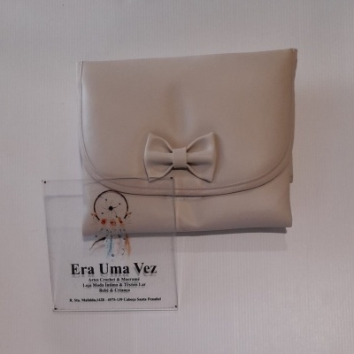 Carteira bege clara com laço decorativo e cartão informativo