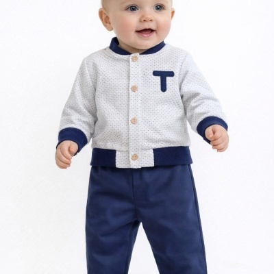 Bebé com camisa branca com pontos pretos, golas e punhos azuis e calças azuis