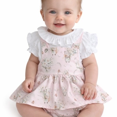 Bebé com vestido cor-de-rosa com ursinhos e flores e blusa branca com folhos