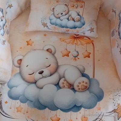 Conjunto de cama de bebé com ursinho a dormir em nuvem azul e estrelas laranja sobre fundo bege