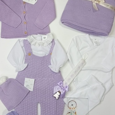 Conjunto bebê lilás e branco com manta, casaco, macacão, body e acessórios numa superfície branca