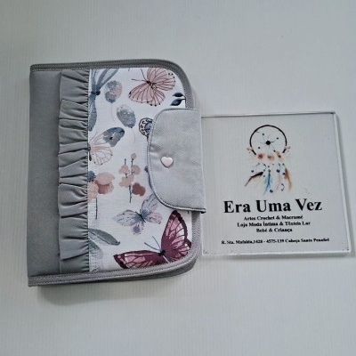 Organizador tecido cinzento com padrão borboletas e flores e placa com texto de marca