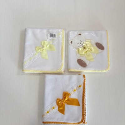 Três panos de tecido branco com renda, fita de cetim e motivos decorativos em fundo claro