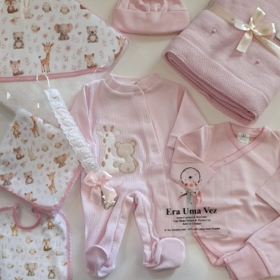 Conjunto de roupa de bebé rosa com pijama de girafa, manta rosa, chapéu, babete e toalha com padrão de animais