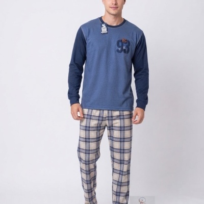 Homem com pijama azul e calças às riscas em fundo branco.
