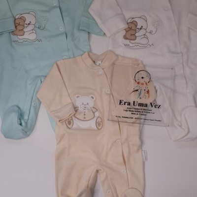 Três macacões de bebé em tecido macio nas cores azul claro, branco e bege com estampas de ursinhos e cartão Era Uma Vez