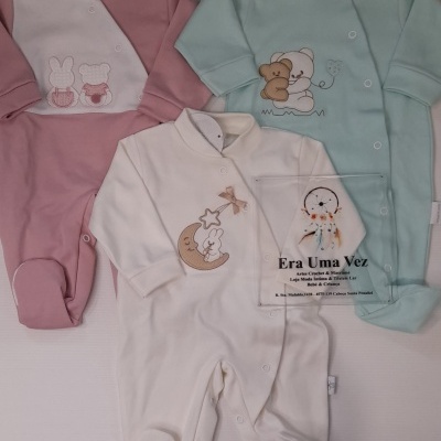 Três macacões para bebé rosa, verde água e branco com bordados e botões de pressão.