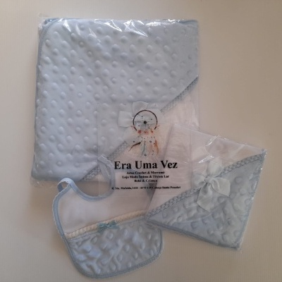 Conjunto de bebé azul claro com manta, babete e toalha de banho texturizados e laços branca