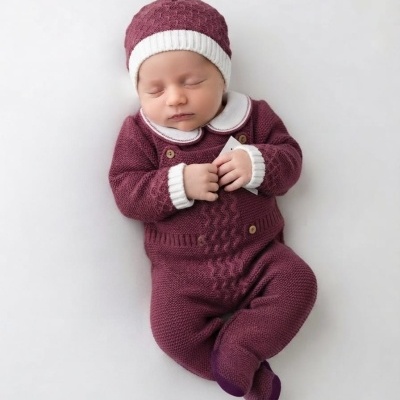 Bebé a dormir com fato e gorro de malha vinho com detalhes em branco
