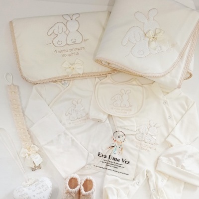 Conjunto de roupa de bebé creme com bordados de coelhos e acessórios decorativos