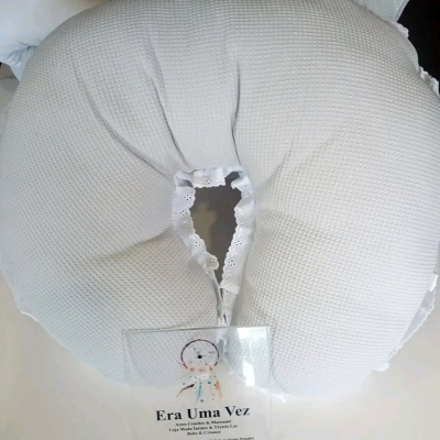 Almofada branca redonda com textura e detalhe rendado centro