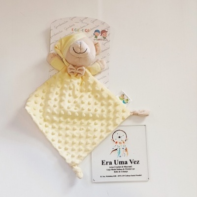 Peluche ursinho amarelo Gamberritos com cartão e cartaz na parede.