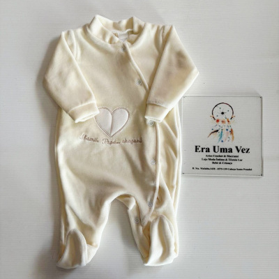 Pijama de bebé creme com bordado e placa publicitária ao lado