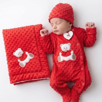 Bebé vestido de vermelho e mantinha vermelha com ursinho bordado