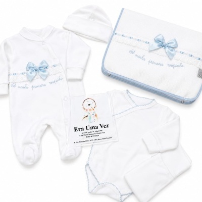 Conjunto de roupa de bebé branco com laços azuis e renda e bolsa com bordado azul
