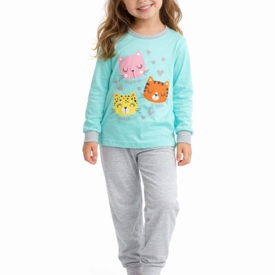Menina com pijama azul claro com estampado de gatos e calças cinzentas.