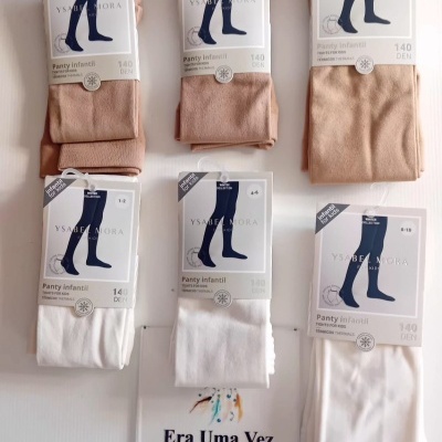 Collants infantis térmicos bege e branco embalados com etiquetas Ysabel Mora e placa de loja 'Era Uma Vez'