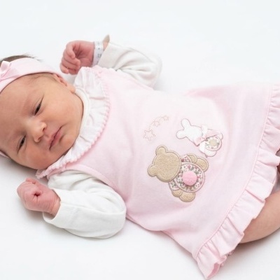 Bebé de vestido rosa com ursinho e faixa rosa com laço