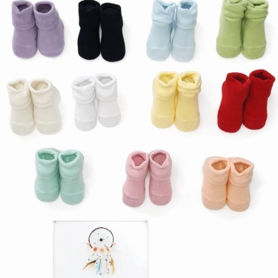 Onze pares de botins para bebé coloridos e placa Era Uma Vez em fundo branco