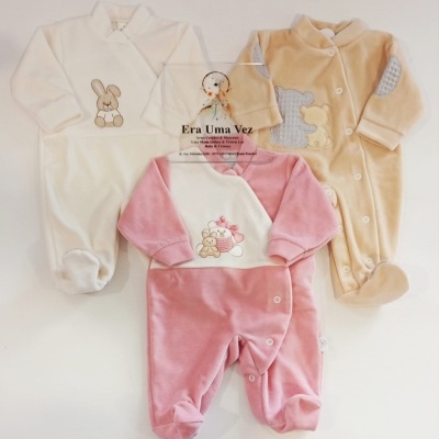 Três macacões de bebé aveludados em branco, rosa e bege, com bordados e aplicações de animais.